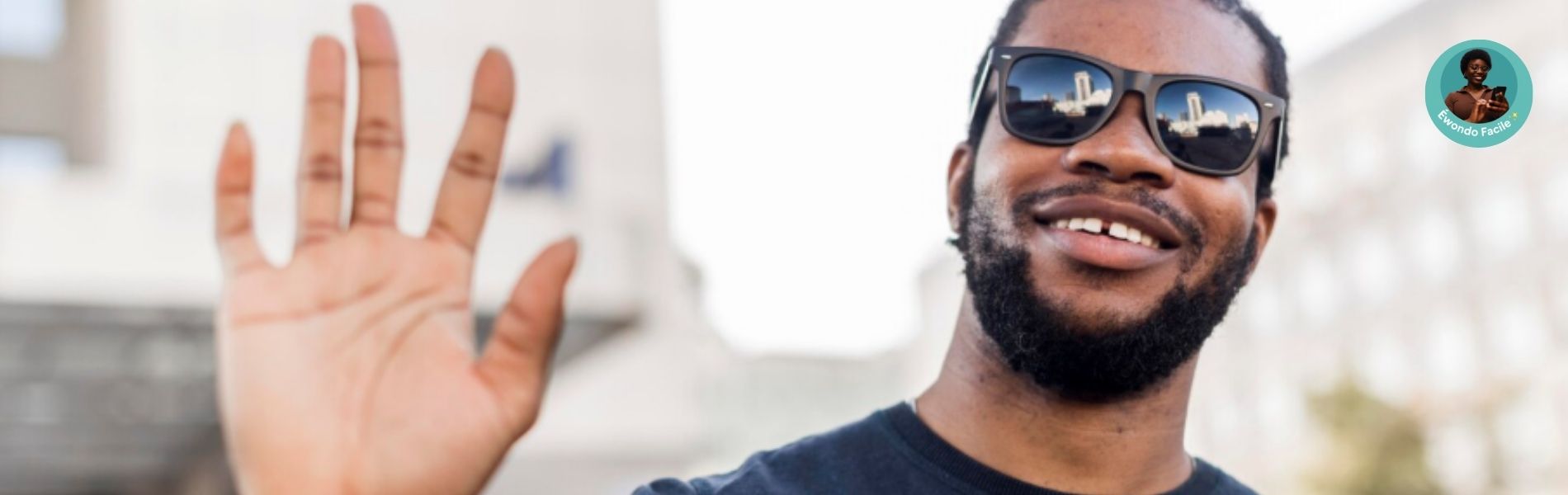 Photo d'un homme africain, look casual, lunettes de soleil : il fait le geste de salut - Cette image représente le quiz "Je parle Ekang" de Dzaleu.net